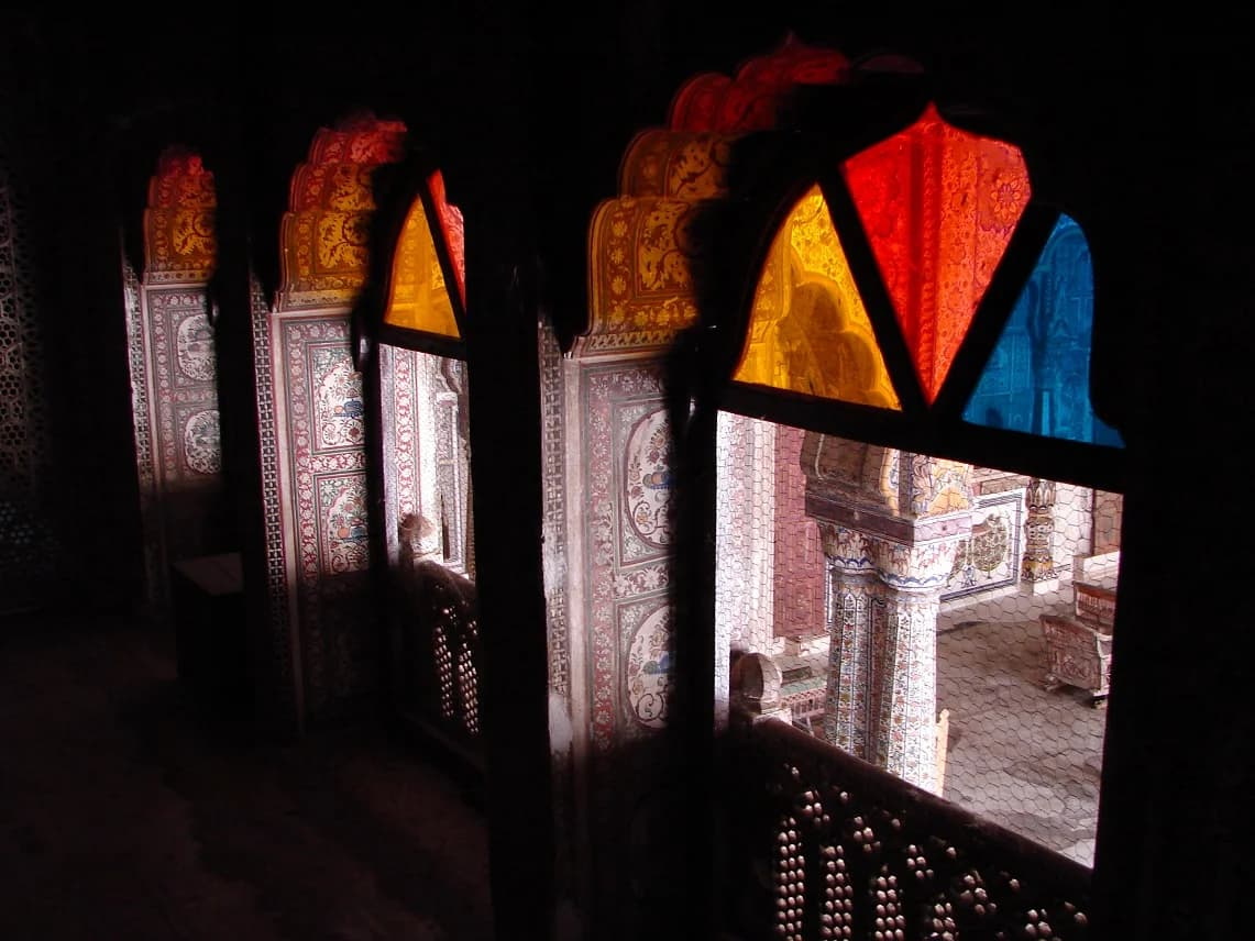 Bhanwar Vilas Palace — the stately colonial-era facade with its grand portico, manicured gardens spreading before it, the ancient town of Karauli a quiet presence beyond the walls