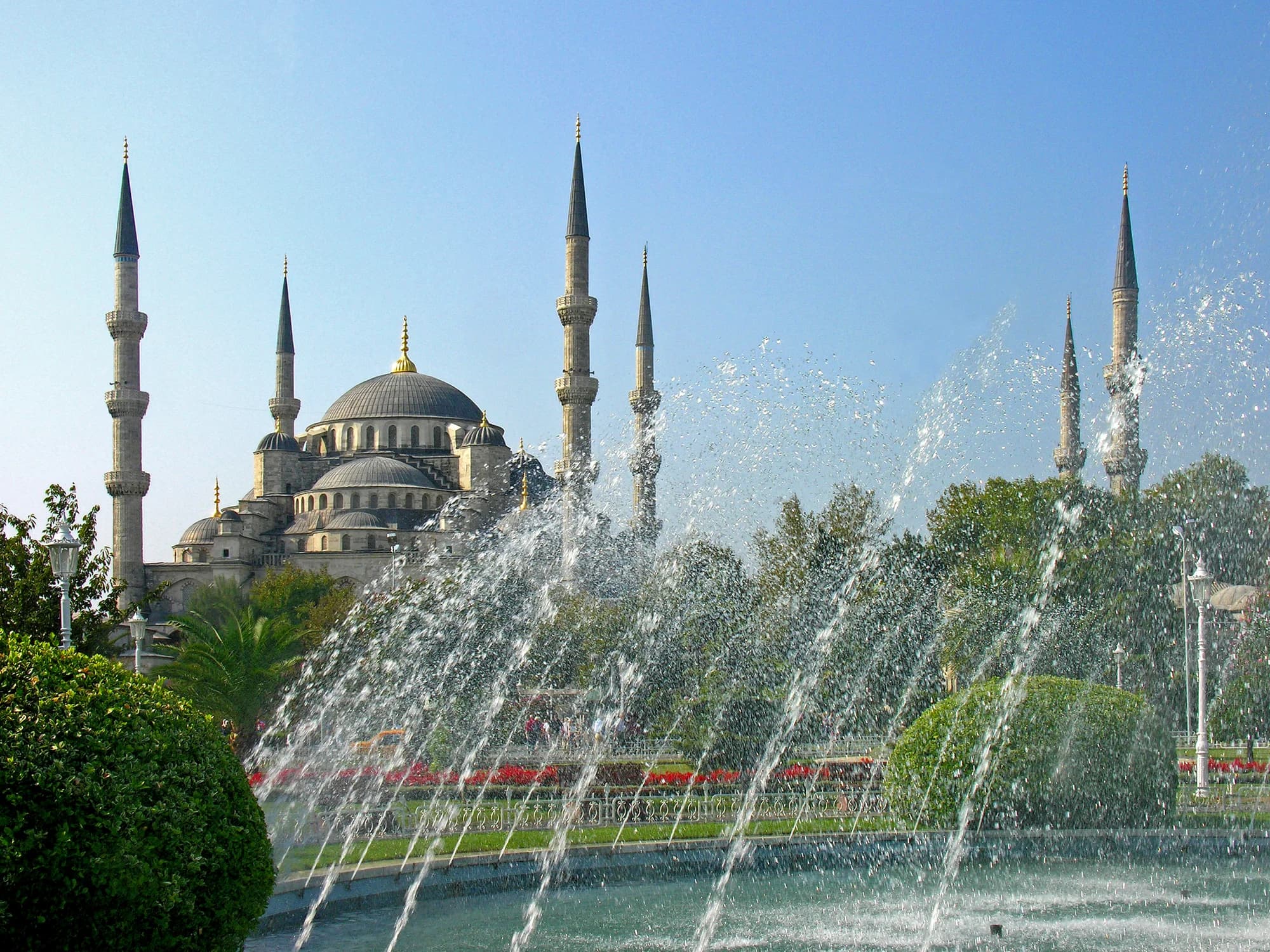 The Blue Mosque at sunrise — six minarets piercing a lavender sky, the cascading domes and semi-domes of the roofline creating a silhouette that has defined Istanbul's skyline since 1616
