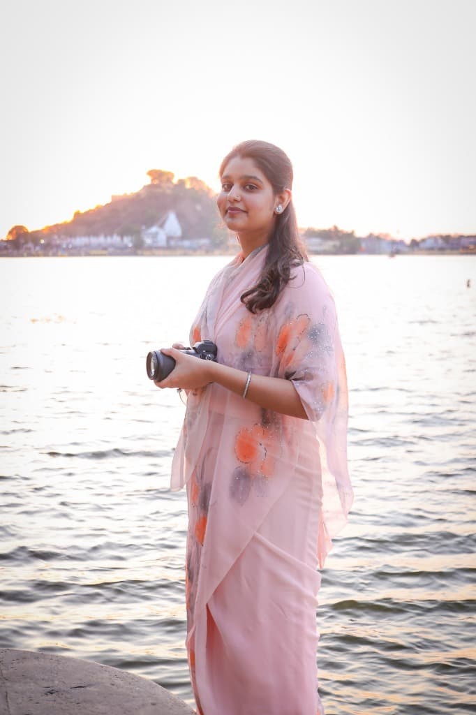 Shivanjali Kumari Dungarpur holding her camera at the Dungarpur lake at sunset