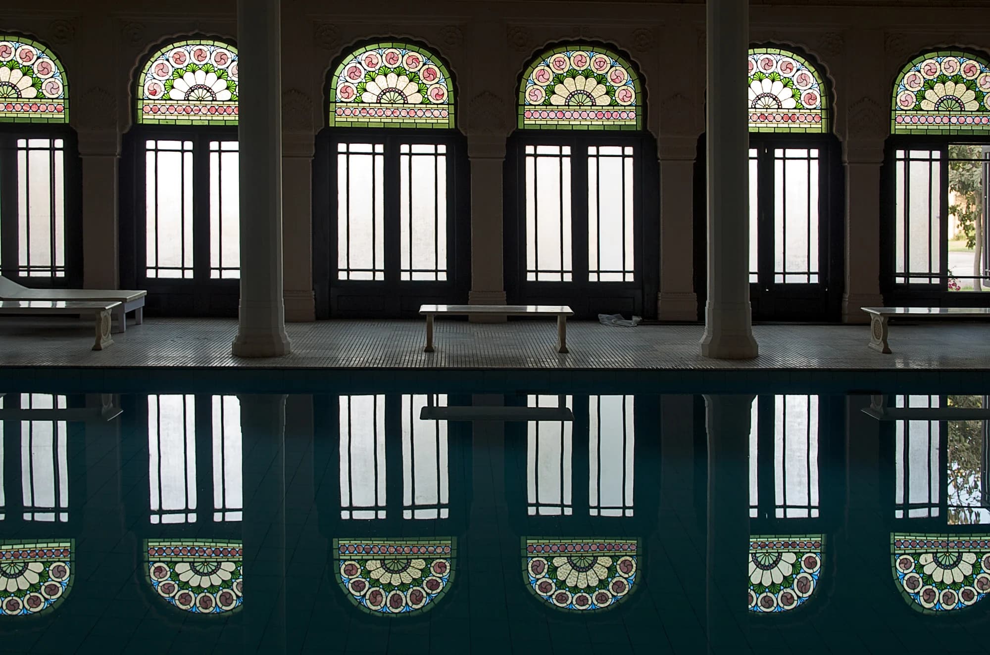 The palace dining room — candlelit tables beneath frescoed ceilings, silver thalis bearing Bikaneri specialities: Ker Sangri, Gatte ki Sabzi, Dal Baati, and the palace's legendary Bikaneri Bhujia