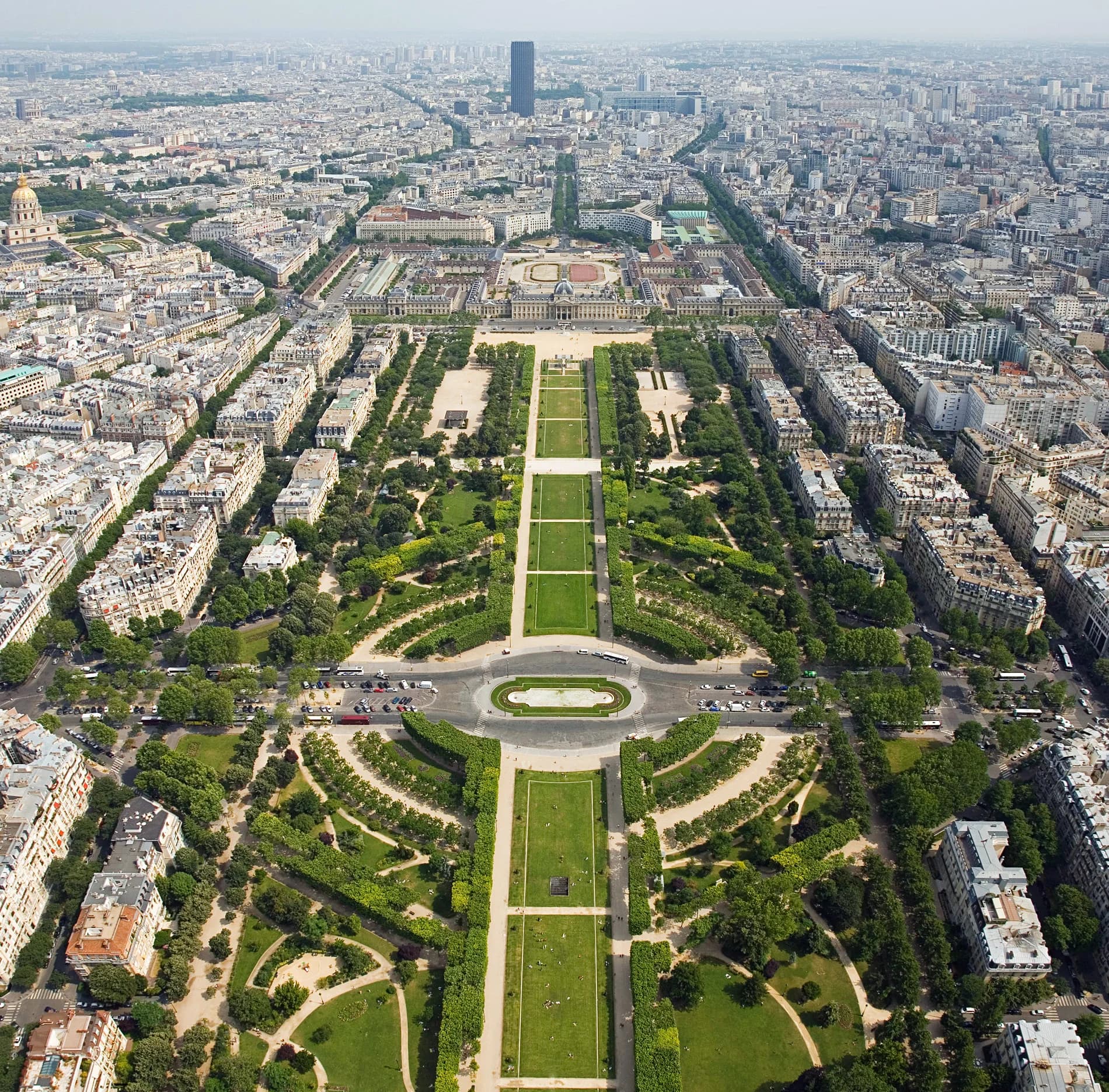 Paris from the top of the Arc de Triomphe at twilight — the twelve avenues radiating outward like the spokes of a wheel, the Eiffel Tower glittering on the hour, the Sacré-Cœur a white dome on its distant hill, the Seine catching the last light, the most beautiful city in the world doing what it has done for centuries — being beautiful, and knowing it, and not caring that you know it too